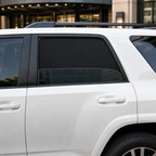 Rear door glass partially lowered behind a fitted magnetic mesh window shade